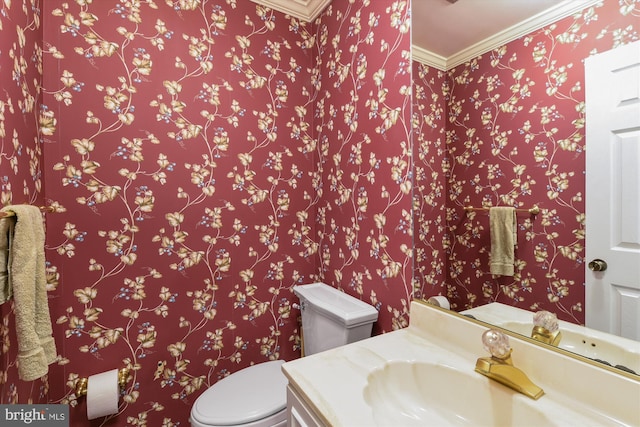 bathroom with toilet, ornamental molding, and vanity