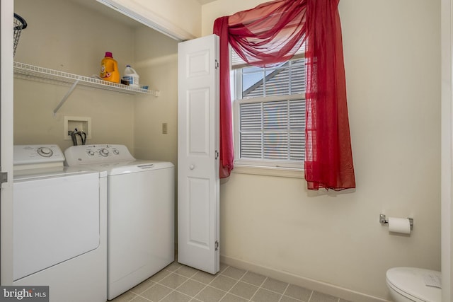 laundry area featuring laundry area, washing machine and dryer, light tile patterned floors, and baseboards