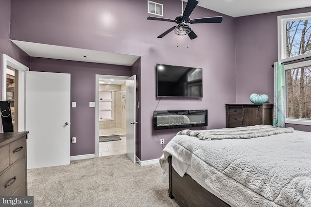 carpeted bedroom with ensuite bath and baseboards