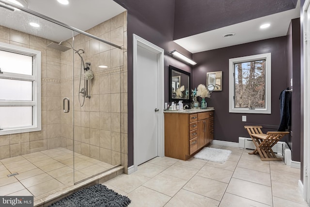 bathroom featuring a stall shower, baseboards, visible vents, tile patterned floors, and vanity