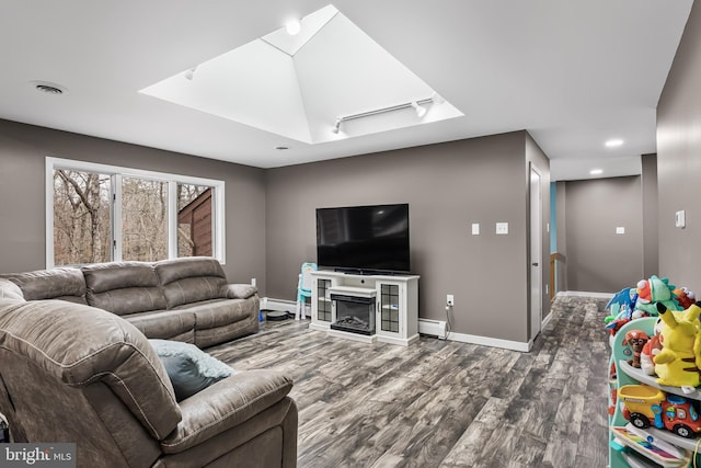 living area featuring a baseboard radiator, visible vents, a baseboard heating unit, wood finished floors, and baseboards