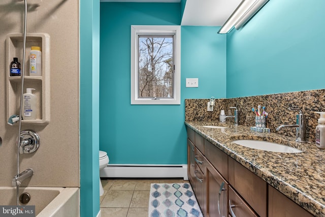 bathroom with double vanity, a baseboard heating unit, a sink, and tile patterned floors