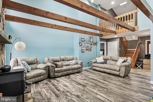 living area featuring recessed lighting, stairway, a high ceiling, wood finished floors, and baseboards