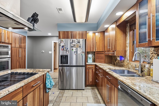 kitchen featuring stainless steel appliances, tasteful backsplash, visible vents, brown cabinetry, and a sink