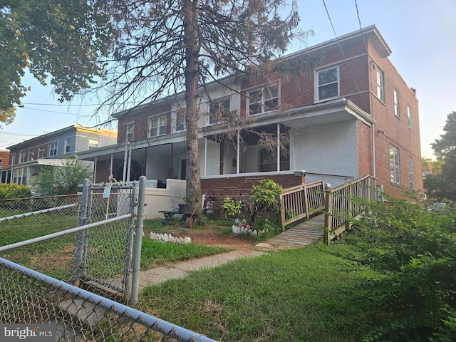 rear view of property with fence and brick siding