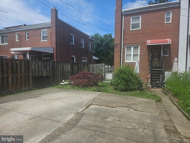 view of side of home featuring fence and brick siding