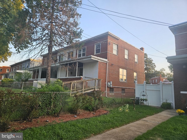 back of house featuring fence and brick siding