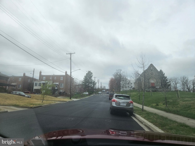 view of street with curbs, street lights, and sidewalks