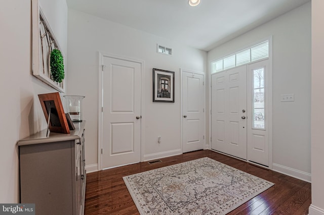 entryway featuring dark wood-type flooring, visible vents, and baseboards