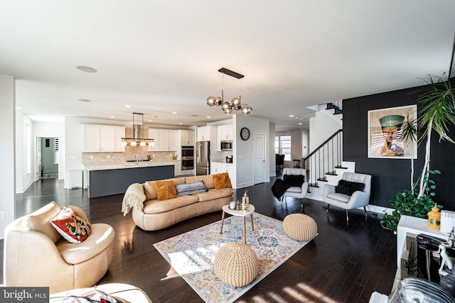 living area featuring recessed lighting, dark wood-type flooring, a chandelier, baseboards, and stairs