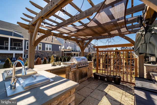 view of patio with fence, grilling area, an outdoor kitchen, and a pergola