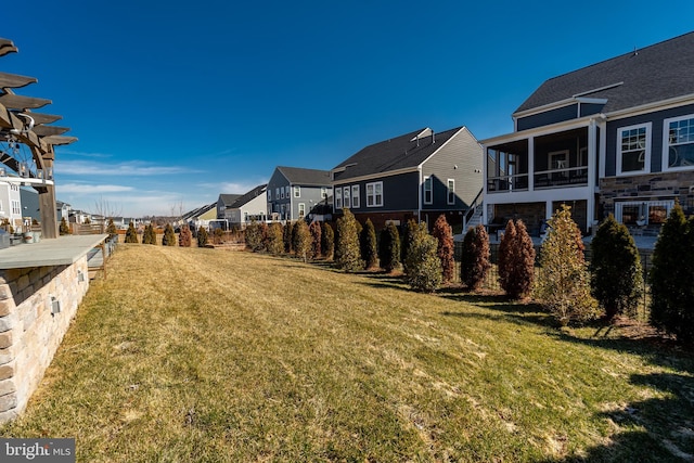 view of yard featuring a sunroom and a residential view