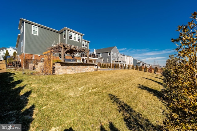 back of house with a residential view, fence, a yard, a pergola, and brick siding