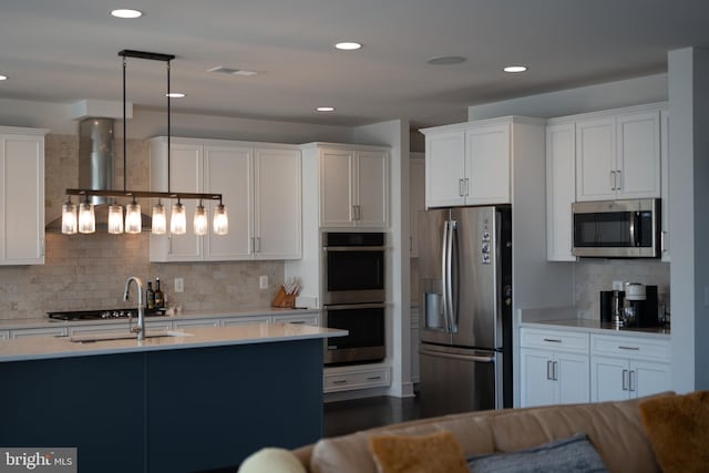 kitchen with stainless steel appliances, light countertops, and white cabinetry