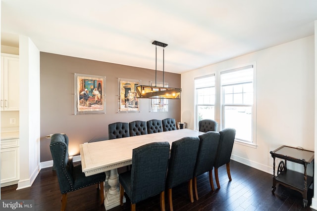 dining area with dark wood-type flooring and baseboards