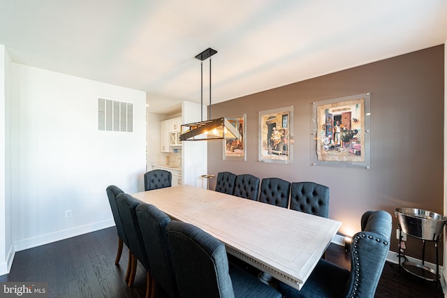 dining area featuring dark wood finished floors, visible vents, and baseboards