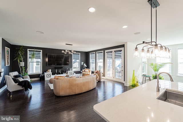 living room with dark wood-style floors, plenty of natural light, and baseboards