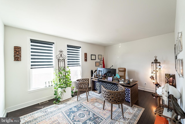 home office with baseboards, hardwood / wood-style floors, visible vents, and a healthy amount of sunlight