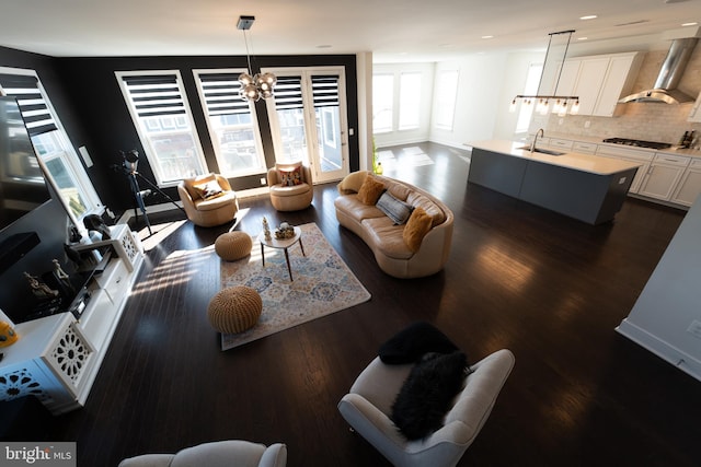 living room with dark wood-style floors, recessed lighting, baseboards, and an inviting chandelier