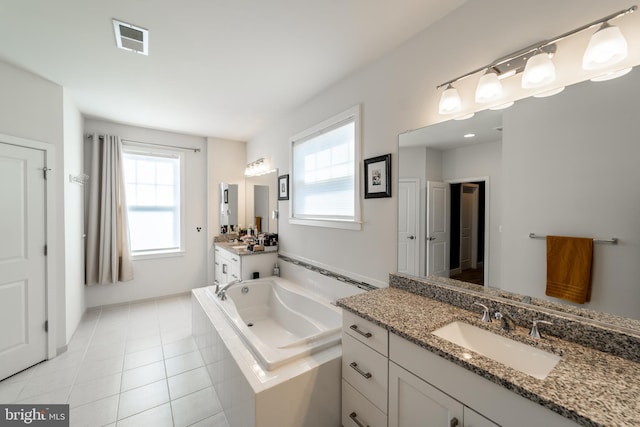 bathroom with a healthy amount of sunlight, visible vents, a sink, and a garden tub