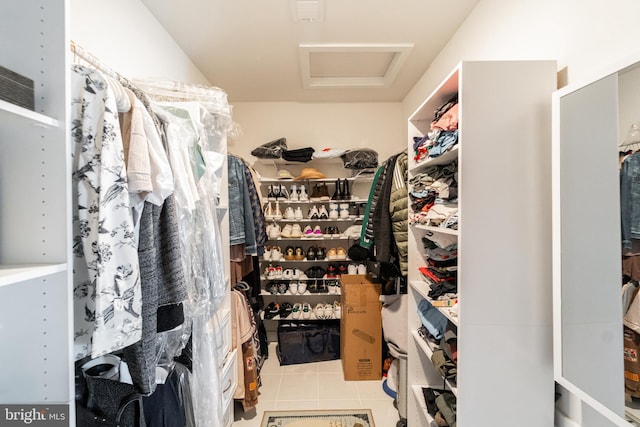 spacious closet featuring light tile patterned floors, visible vents, and attic access