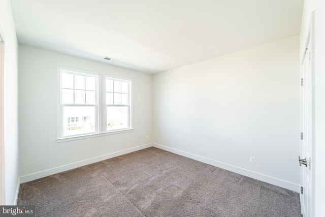 carpeted empty room featuring visible vents and baseboards