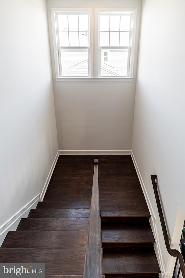 stairs with a healthy amount of sunlight, baseboards, and wood finished floors