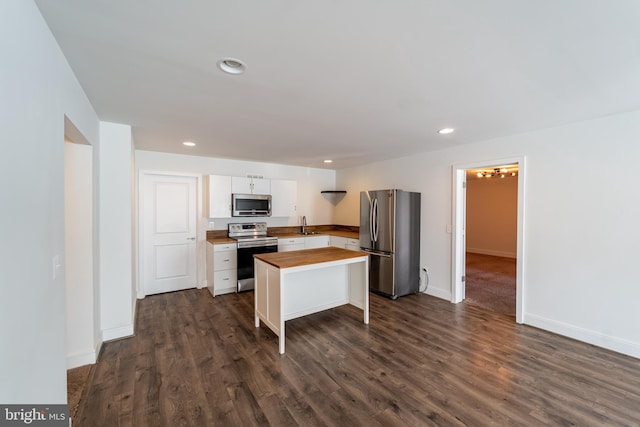 kitchen with dark wood-style flooring, stainless steel appliances, wooden counters, and recessed lighting