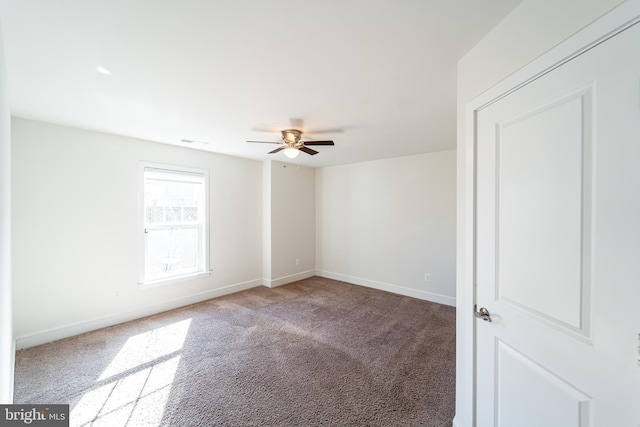 empty room featuring ceiling fan, carpet floors, visible vents, and baseboards