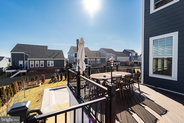 wooden terrace featuring outdoor dining space and a residential view