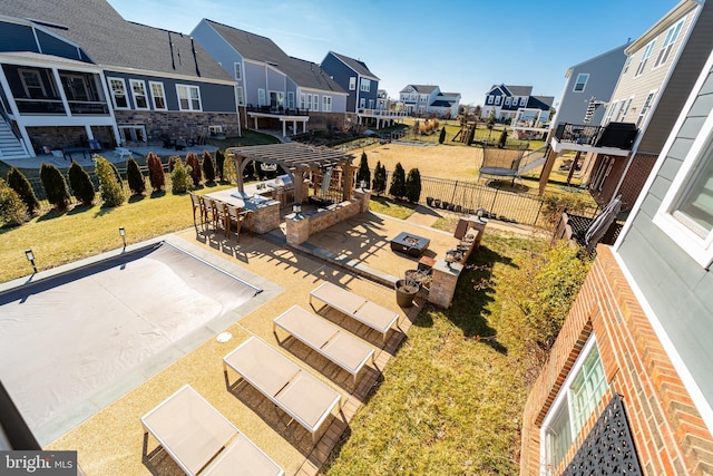 exterior space with an outdoor fire pit, fence, and a residential view