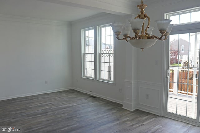 unfurnished dining area featuring a notable chandelier, crown molding, baseboards, and wood finished floors