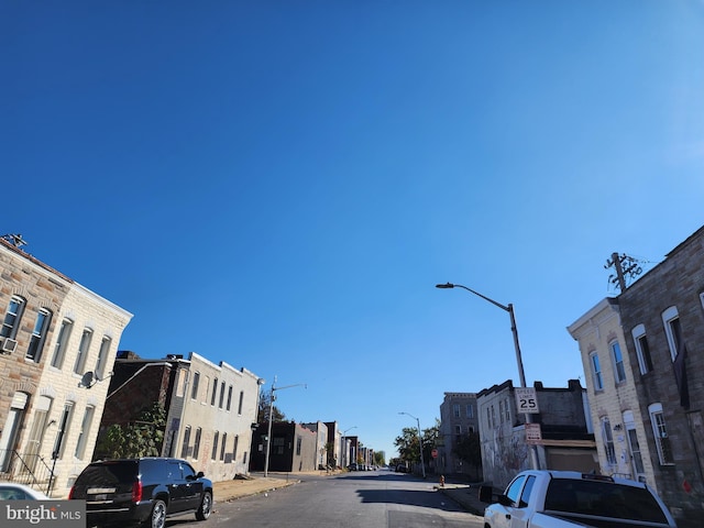 view of road featuring street lighting, curbs, and sidewalks