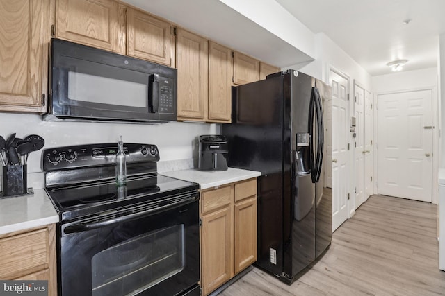 kitchen featuring black appliances, light countertops, and light wood-style floors