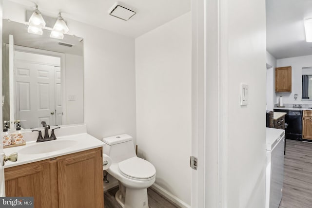 bathroom featuring toilet, visible vents, wood finished floors, and vanity