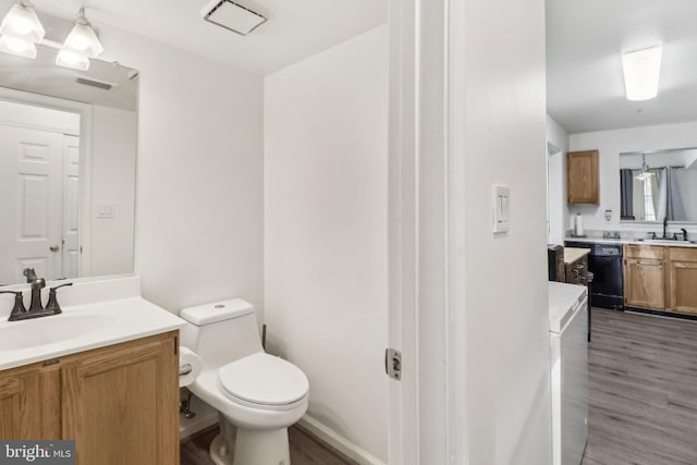 bathroom featuring toilet, visible vents, wood finished floors, and vanity