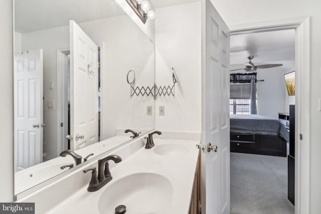 bathroom featuring connected bathroom, a sink, ceiling fan, and double vanity