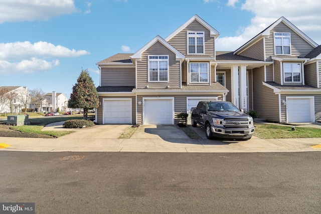 view of front of property with a garage, driveway, and a shingled roof