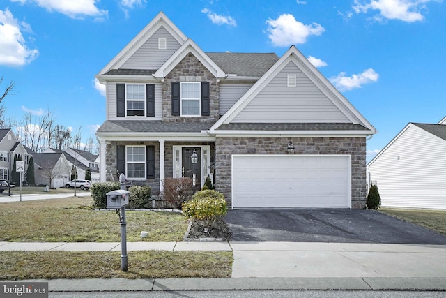 view of front of property with aphalt driveway, a front yard, stone siding, and a shingled roof