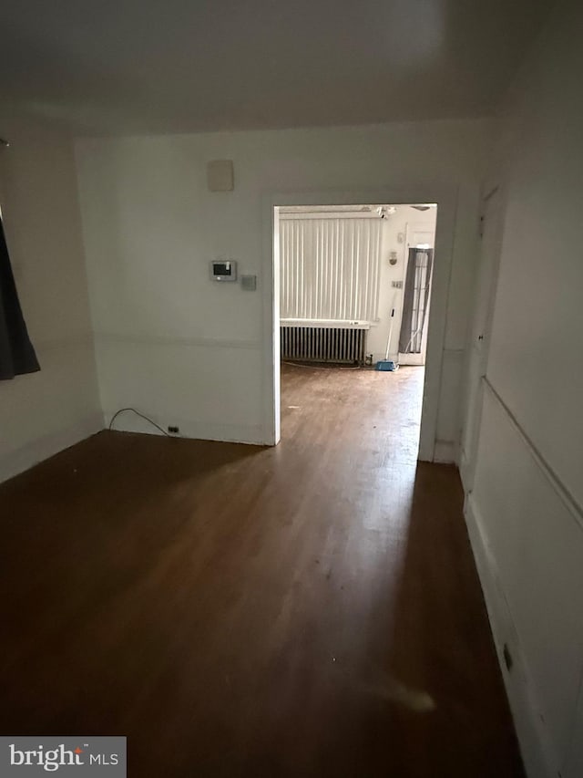 empty room with radiator and wood finished floors