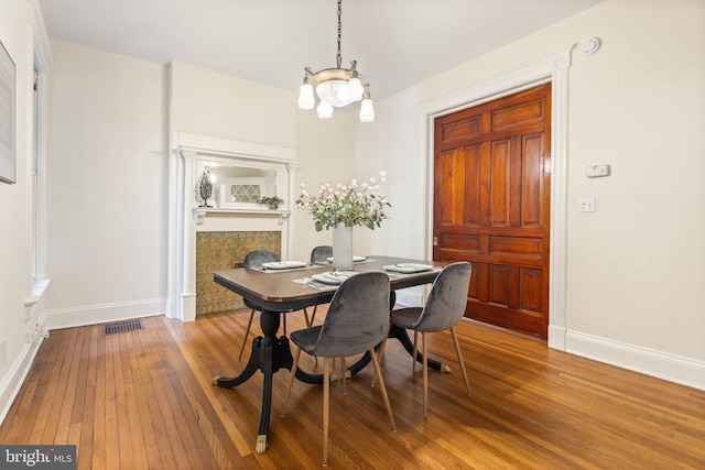 dining area featuring wood-type flooring, visible vents, and baseboards