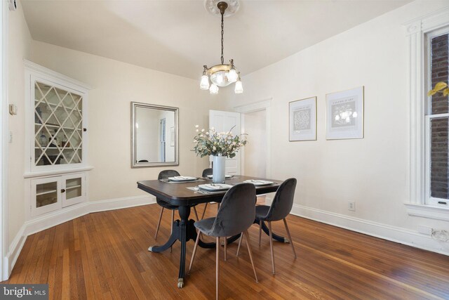 dining area with an inviting chandelier, baseboards, and wood finished floors