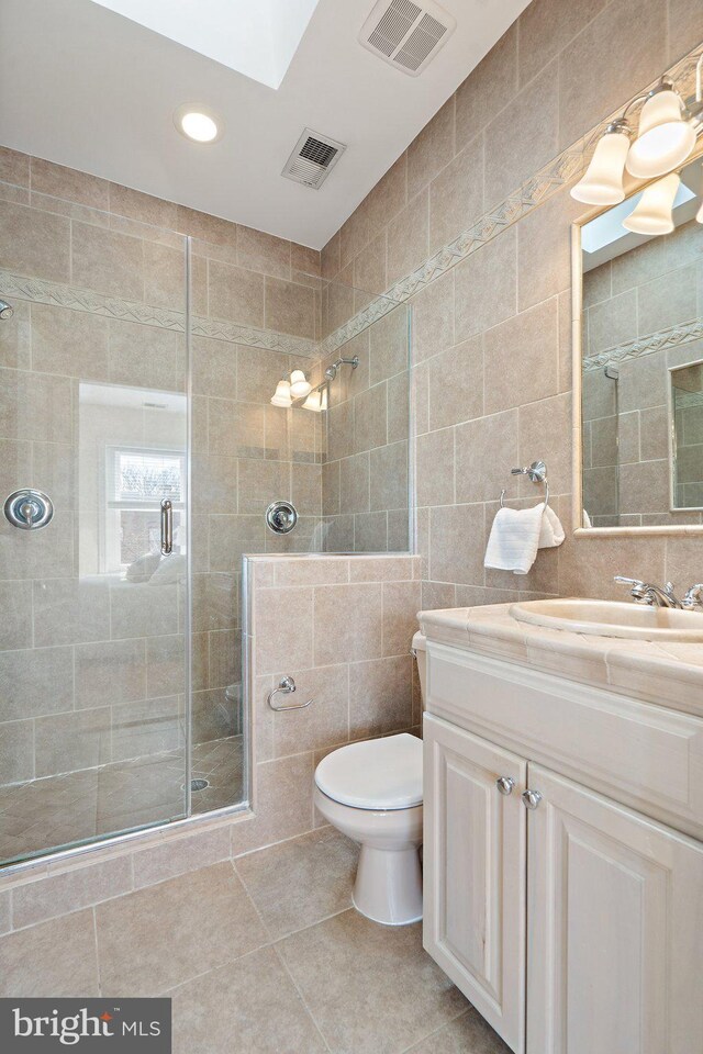bathroom with visible vents, a stall shower, tile patterned flooring, and tile walls