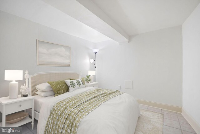 tiled bedroom with baseboards and beam ceiling