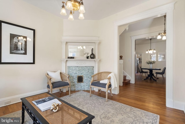 sitting room featuring wood finished floors, visible vents, baseboards, and an inviting chandelier