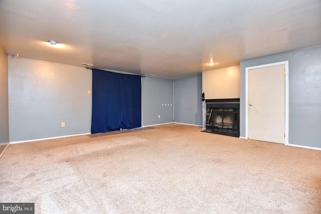 unfurnished living room featuring baseboards, carpet, and a fireplace