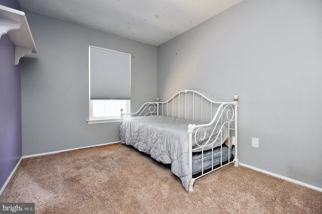 bedroom with baseboards and carpet