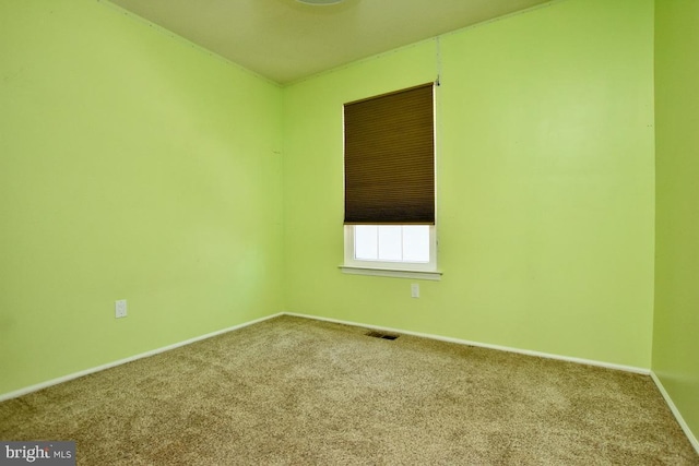 carpeted spare room featuring visible vents and baseboards