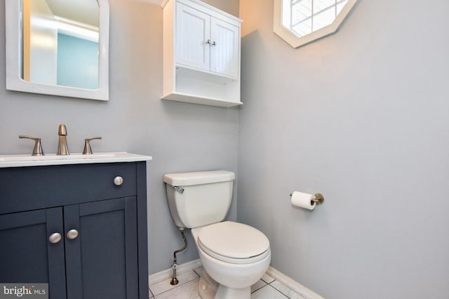 bathroom with tile patterned floors, baseboards, toilet, and vanity