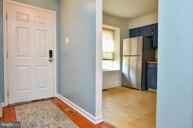 interior space featuring visible vents, light wood-style flooring, and baseboards